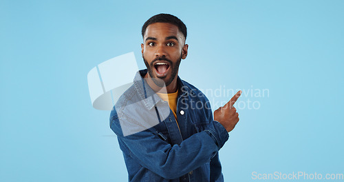 Image of Advertising studio smile, man and pointing at ads commercial, retail information or discount announcement. Sales info, mockup space and portrait person show service, deal or news on blue background