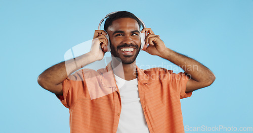 Image of Man, student and headphones for listening to music, dance and mental health for education and wellness in studio. Young african person for audio streaming service, techno or rave on a blue background