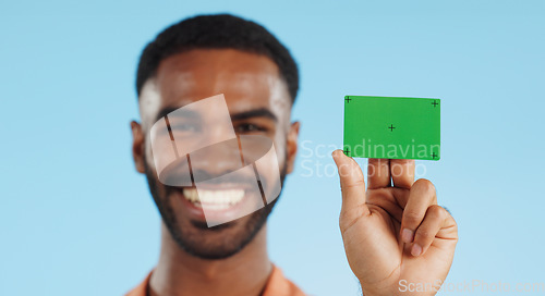 Image of Man, credit card and happy with green screen in studio for mockup, bank logo and face by blue background. Person, space and chromakey with tracking markers for fintech brand, review or promotion