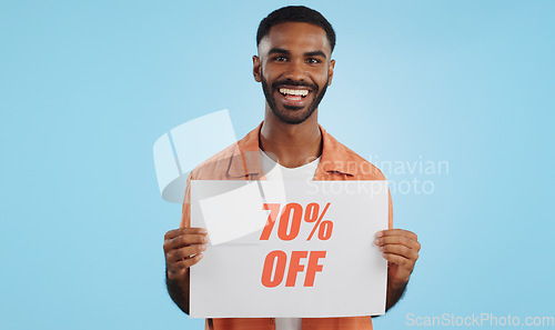 Image of Discount, sign and promotion, man and portrait, show information and smile isolated on blue background. Poster, billboard or banner with sale news, announcement on board with advertising in studio