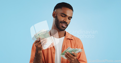 Image of Man, count cash and happy in studio with success, bonus or promotion with winning by blue background. Investor, trader or person with Euro money, salary or savings with smile for financial freedom go
