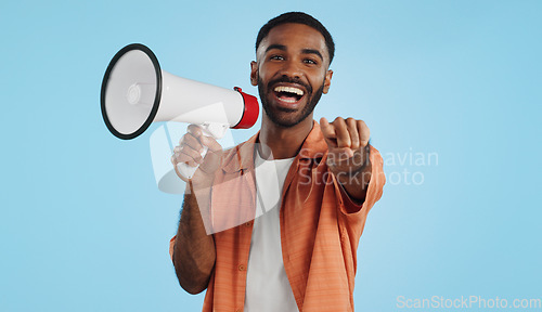 Image of Young man, megaphone and announcement, choice or broadcast for winner, join us or winning opportunity in studio. Face of african person with voice, pointing you and competition on a blue background