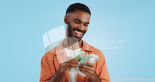 Image of Man, count cash and happy in studio with success, bonus or promotion with winning by blue background. Investor, trader or person with Euro money, salary or savings with smile for financial freedom go