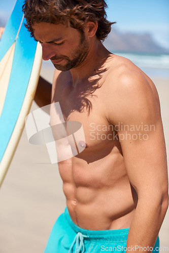 Image of Beach, fitness and man at a beach with surfboard for training, cardio or water sports. Surfing, freedom and male surfer at the sea for summer, fun and adventure, travel or holiday, workout or hobby
