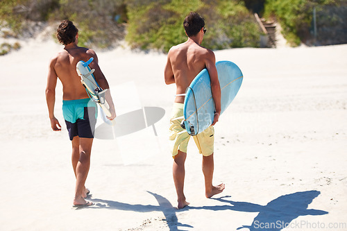 Image of Surfing, back and men friends at a beach for fitness, adventure or training in nature together. Travel, freedom and surfer people walking at sea for water sports, bonding and summer vacation in Bali