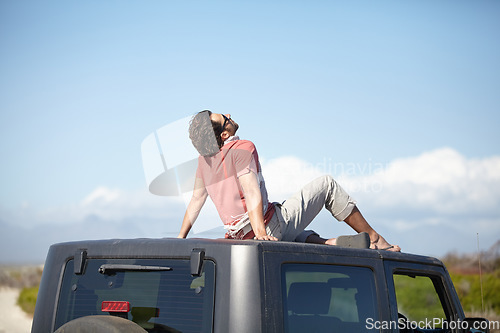 Image of Travel, man and sitting on van roof for scenery, nature and fresh air on adventure or vacation in South Africa. Person, tourist or traveler on rooftop of car with sunglasses for view or road trip