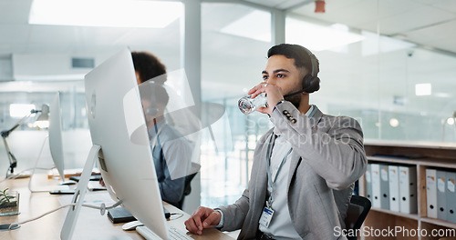 Image of Happy businessman, call center and drinking water in customer service or telemarketing at office. Thirsty man, consultant or agent talking with headphones and drink for online advice, support or help