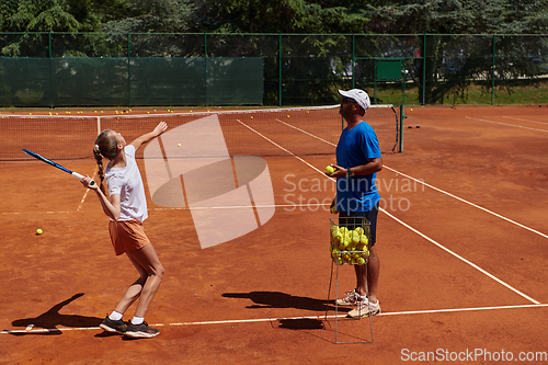 Image of A professional tennis player and her coach training on a sunny day at the tennis court. Training and preparation of a professional tennis player