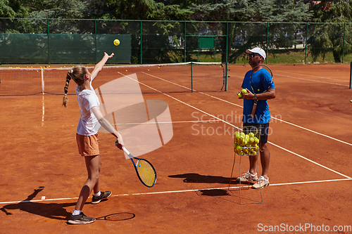 Image of A professional tennis player and her coach training on a sunny day at the tennis court. Training and preparation of a professional tennis player