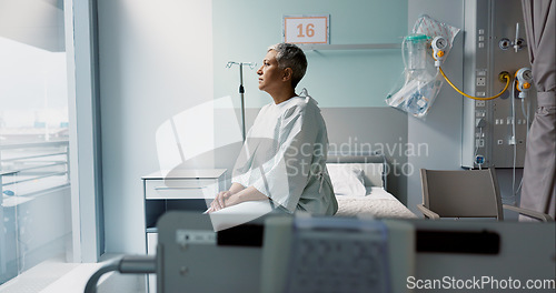 Image of Sad, patient and thinking in hospital with window and stress, anxiety or fear of cancer, death and insurance. Senior, woman and depression in clinic with lady worried for future or mental health