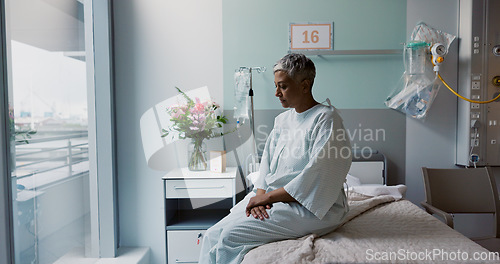 Image of Sad, woman and thinking at window in hospital with stress, anxiety or fear of cancer, death or insurance. Senior, patient and depression in clinic with lady worried on bed for future or mental health