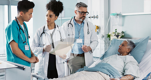 Image of Healthcare, documents and a medical team of doctors checking on a patient in recovery or rehabilitation. Medicine, teamwork and explain with a group of health professionals in a hospital for wellness