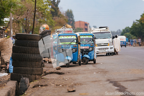 Image of Street in Addis Zemen showcasing traditional blue tuk-tuk vehicles, a popular mode of transportation in the cities in Ethiopia.