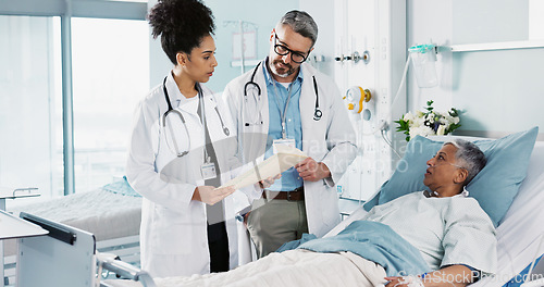 Image of Healthcare, documents and a medical team of doctors checking on a patient in recovery or rehabilitation. Medicine, teamwork and explain with a group of health professionals in a hospital for wellness
