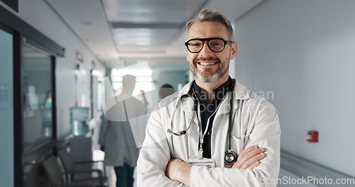 Image of Doctor in portrait, senior man with arms crossed and healthcare, smile with confidence at hospital with pride and help. Medical professional, trust and happy at clinic with expert and stethoscope