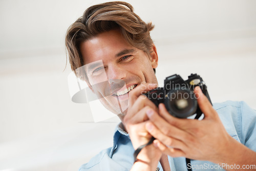 Image of Production, camera and portrait of man photographer at a photoshoot for creative work project. Happy, photography and handsome young male person with dslr device for art career by white background.