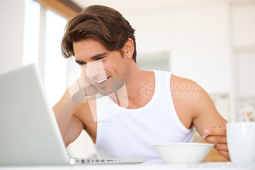 Image of Laptop, eating and man watching a movie, film or show on streaming website or the internet. Technology, smile and young male person enjoying cereal and video on social media with computer at home.