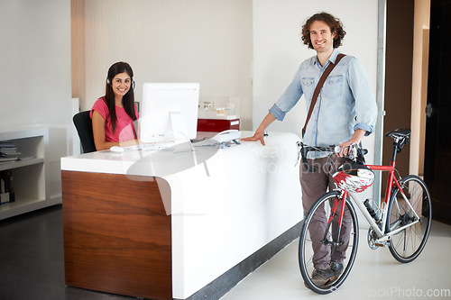 Image of Man, office with bike and sustainable travel, worker in portrait with carbon footprint, transportation and creative at startup. Happy, cycling for eco friendly commute and professional at workplace