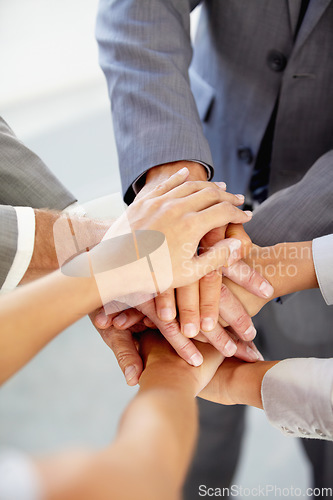 Image of Hands, collaboration and a business team in a huddle at the office together from above for unity or solidarity. Teamwork, support or circle with an employee group of men and woman in a workplace