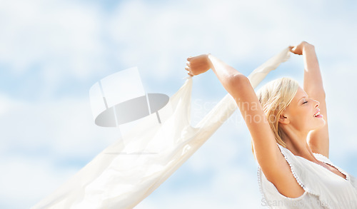 Image of Woman, holding or fabric with blue sky in nature, field or outdoor for freedom, peace and happy. Person, beauty or smile with scarf, breeze or wind for relaxing, lifestyle or tranquility with mockup