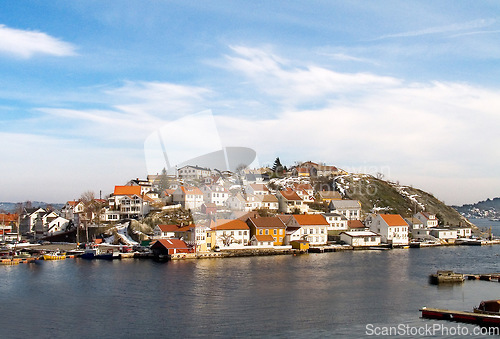 Image of Island, water and houses at ocean in Norway, Europe and tourism, travel or vacation. Exterior, home and Scandinavian buildings at sea, vintage architecture or traditional property with boats at port