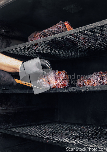 Image of Meat prepared in barbecue smoker.