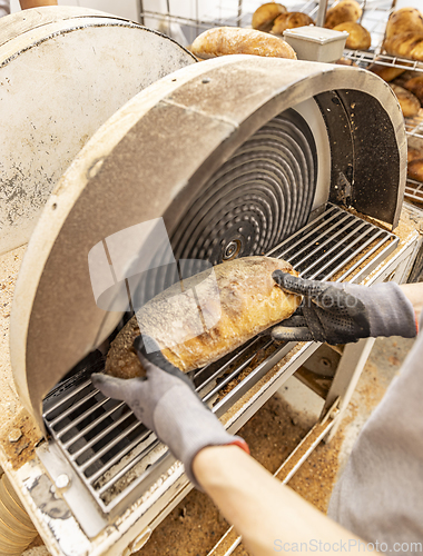 Image of Worker grate bread crust in factory