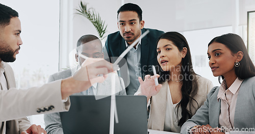 Image of Wind turbine, computer and man in office team working on clean energy and sustainability planning. Engineering, construction project and architect job with eco friendly and biodiversity design