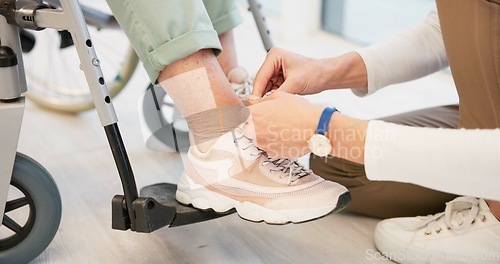 Image of Caregiver, help and senior woman in wheelchair with shoes in closeup for comfort, care. Nurse, hand and sneakers for elderly person with disability in retirement home for support with medical worker.