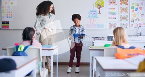 Image of School, child and reading a book in class for learning, development and communication. A african boy kid or student and teacher woman for language, support and assessment in elementary classroom