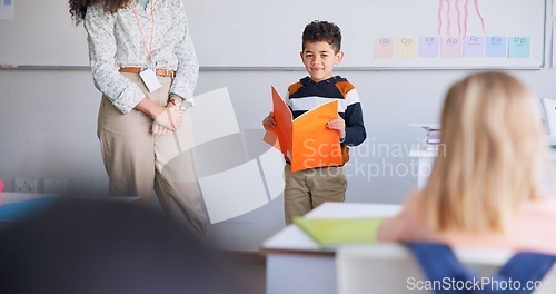 Image of Child, student and reading a book in class for learning, development and communication. Boy kid and woman teacher for language, support and assessment or confidence in elementary classroom at school