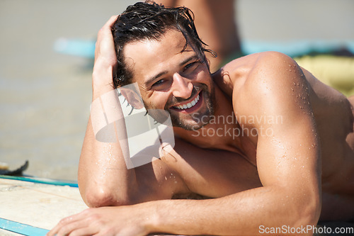 Image of Beach, surfing and portrait of happy man relax, tired and rest after island activity, outdoor cardio or summer freedom. Australia holiday, sports and wet person smile, happiness or lying on surfboard