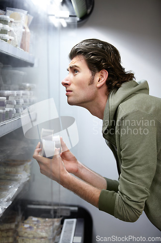 Image of Man, thinking and grocery store choice or product comparison, price concern or food inflation rate. Male person, budget selection and savings stress for supermarket shopping, decision or expenses