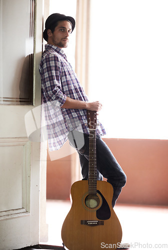 Image of Musician, portrait and man with a guitar, instrument and singer in a music studio. Creative, artist and guitarist standing in home and thinking of performance, equipment or listening to rock audio