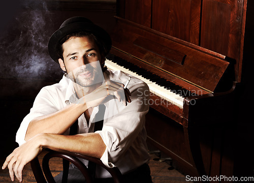 Image of Portrait, artist and man with a piano, smoking and creative with talent, performance and gig. Face, musician and club with a cigarette, jazz and ambient with tobacco, smile and confident player