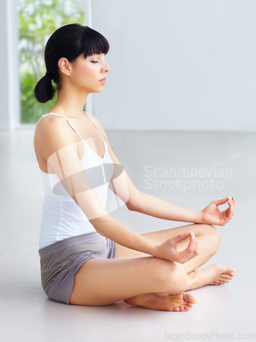 Image of Yoga meditation, floor and calm woman meditate for spiritual peace, chakra balance or soul healing, self care or breathing. Eyes closed, studio and person relax for mindfulness, mindset or wellness