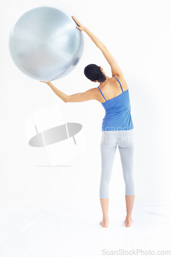 Image of Woman, exercise or ball with back for yoga, exercise or workout on muscle, posture and healthy body. Person, arm or stretching for pilates, training or fitness with sportswear and technique in studio