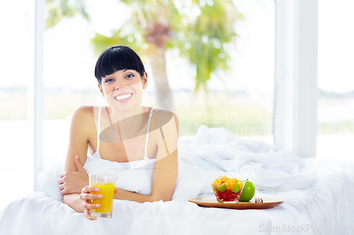 Image of Orange juice, happy portrait and bedroom woman with glass drink for morning hydration, liquid detox or natural wellness. Fruit salad, home bed and nutritionist thirsty for organic citrus beverage
