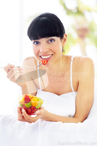 Image of Fruit salad, home bed and portrait of happy woman with organic meal, snack or morning breakfast for healthy lifestyle balance. Apartment bedroom, strawberry benefits or relax person eating vegan food