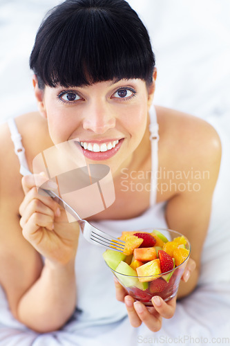 Image of Fruits salad, happiness and bedroom portrait of woman with natural organic meal, snack or morning breakfast for healthy lifestyle. Home apartment bed, face and nutritionist smile for vegan food mix