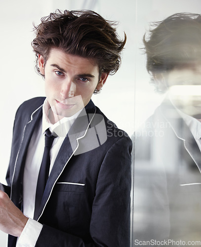 Image of Fashion, formal and portrait of man in a studio with blazer, classy and elegant outfit for confidence. Handsome, suit and young male model with trendy and cool style with reflection in glass