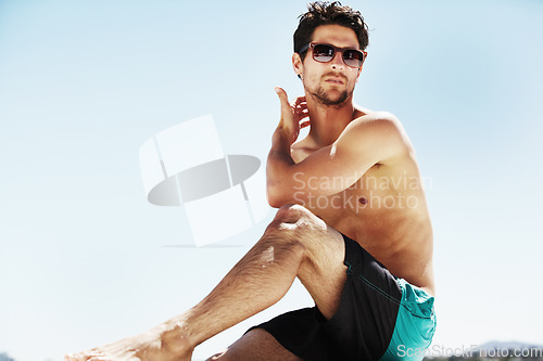 Image of Sunglasses, beach and man relax on holiday, vacation or travel for tropical tourism on a blue sky mockup space. Summer, serious person in swimwear and sunbathe outdoor, fashion style and thinking