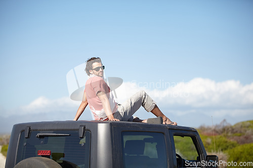 Image of Road trip, man and roof of car for view, scenery, nature and fresh air on adventure or vacation in Africa. Person, tourist or traveler on rooftop with sunglasses and sky mockup for peace or journey