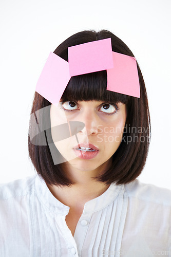 Image of Stress, sticky note and the head of a business woman in studio isolated on a white background with a to do list. Face, thinking and confused with a young employee in doubt about a task closeup