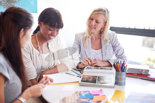 Image of Business women, teamwork and meeting for magazine planning, collaboration or photograph and clients ideas. Designer group, manager and people with print, book catalog or portfolio at marketing agency