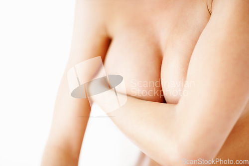 Image of Nude, body and awareness for breast cancer with a woman closeup in studio isolated on a white background. Medical, health and wellness with a naked person covering her skin for plastic surgery