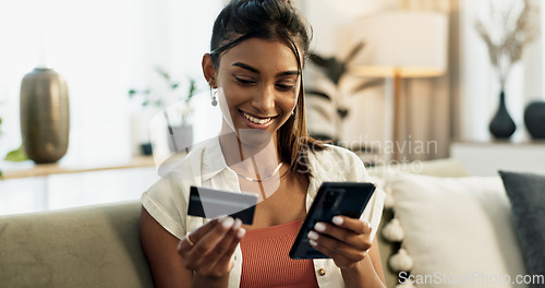 Image of Woman, credit card and phone on sofa, smile or reading with cybersecurity, fintech app or bank info in home. Girl, smartphone and payment for password, budget or online shopping on e commerce website