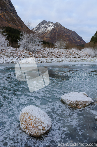 Image of frozen river with sparkling stones in the foreground and sparkli