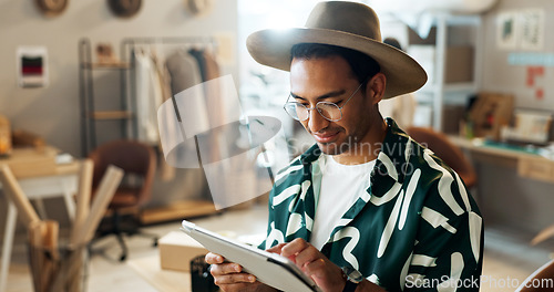 Image of Man, typing and tablet in small business for fashion, shipping and planning supply chan schedule. Reading, reviews or employee update online shopping app in workshop with retail inventory checklist