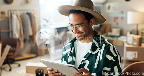 Image of Man, typing and tablet in small business for fashion, shipping and planning supply chan schedule. Reading, reviews or employee update online shopping app in workshop with inventory or checklist